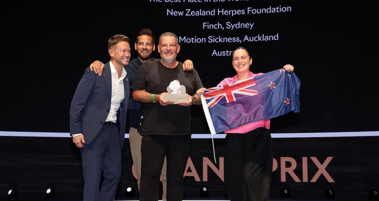 New Zealand Herpes Foundation team winning the Grand Prix for Good at Cannes Lions, with NZ flag